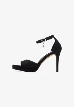 Sandalia de tacón alto de ante negro, con punta abierta, correa en el tobillo con hebilla y plataforma para mayor altura. Textura suave y diseño elegante.