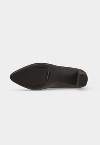 Semelle d'une chaussure plate noire à bout pointu avec des zones antidérapantes texturées au talon et à l'avant.