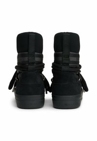Sorte suede højtopsneakers med strikket krave, snøre detaljer og metalliske accenter. "TOMMY HILFIGER" branding på hæl og rem.
