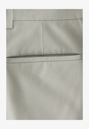 Tejido gris claro con una textura suave, que presenta un diseño de bolsillo plano y un sutil detalle de costura, adecuado para vestir de forma formal o casual.