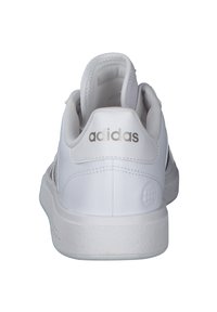 Baskets de sport blanches avec un dessus en synthétique lisse, dotées d'un col rembourré, d'une semelle intermédiaire texturée et d'un logo métallique au niveau du talon.