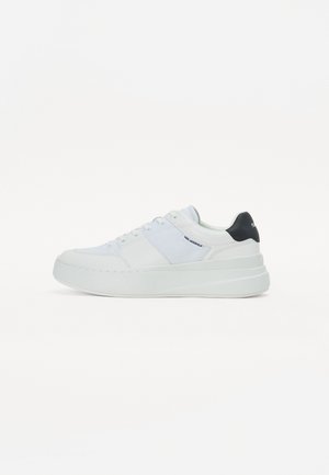 White sneaker with smooth leather and textile upper, round toe, flat sole, and contrasting black heel accent. Features lace-up closure.