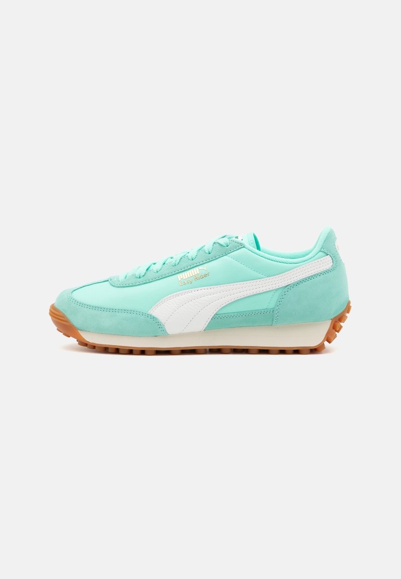 Basket en daim vert menthe avec des accents blancs, dotée d'une semelle en caoutchouc, d'un laçage et d'un logo doré. Forme classique de chaussure de course.