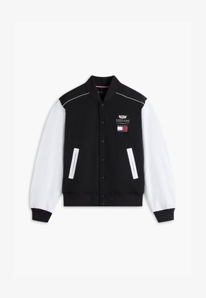 Chaqueta universitaria en blanco y negro con botones de presión, dos bolsillos delanteros y los logotipos de Cadillac Formula Team y Tommy Hilfiger en el pecho.