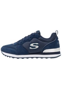 Marinblå sneakers med vit sula, övre i mesh och mocka, snörning, och en silverfärgad "S"-logotyp på sidan.