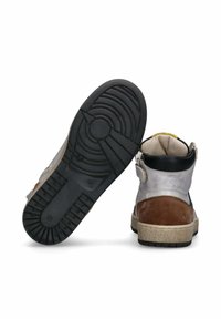 Hoge sneaker met suede bruine hiel, zilveren bovenkant, zwarte gewatteerde kraag, beige zool en zwarte rubberen buitenzool met profielpatroon.