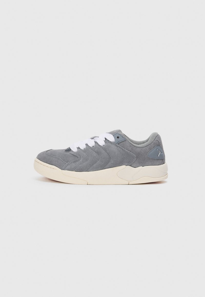 Sneaker grigia in suede con tomaia texture, lacci bianchi e suola in gomma beige. Presenta un logo discreto sul lato.