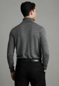 Pulover gri din tricot, cu mâneci lungi, guler și manșete cu dantelă, asortat cu pantaloni negri îngustați, accentuat de o curea neagră.