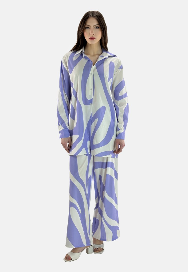 To-delt outfit bestående af en langærmet skjorte med knapper og bukser med vide ben. Stoffet har et blåt og hvidt abstrakt mønster.