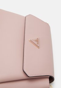 Roze nepleder handtas met een driehoekige gouden logo-accent en contrasterende zwarte stiksels. Beschikt over een klep-sluiting en een gladde textuur.