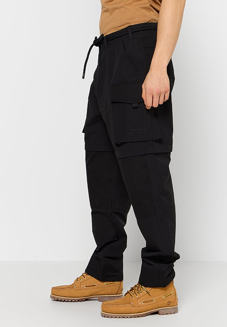 Pantalons cargo noirs en matériau léger, dotés de plusieurs poches, d'une taille ajustable avec cordon de serrage, et d'une coupe décontractée.