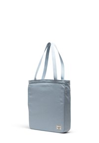 Ljusblå tote-väska i hållbart tyg med två axelremmar och en etikett i nedre högra hörnet. Slät struktur, rektangulär form.