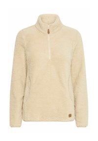 Cream-colored fleece pullover with a half zip, high collar, and side pockets. Features a textured, soft surface and a small brand patch at the hem.