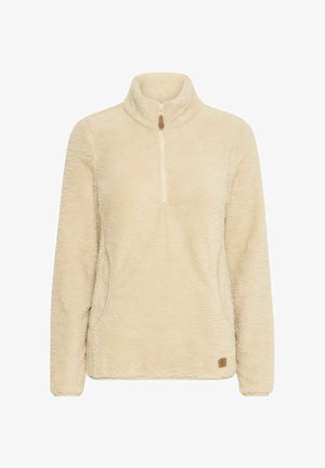 Cream-colored fleece pullover with a half zip, high collar, and side pockets. Features a textured, soft surface and a small brand patch at the hem.