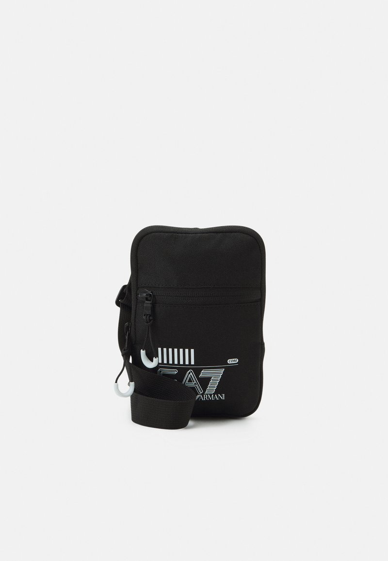 Borsa a tracolla nera in nylon con chiusura a zip, caratterizzata da una stampa del logo e una tracolla staccabile. Forma rettangolare compatta con un design minimalista.