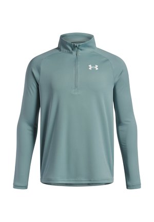 Long-sleeve, teal half-zip pullover made of smooth, breathable fabric with white logo detail on the left chest and flat seams.