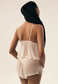 Przezroczysta różowa bluzka z szyfonu z regulowanymi ramiączkami, warstwowym wzorem i pasującymi szortami z haftem kwiatowym po boku.