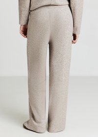 Hellbeige Hosen mit weitem Bein aus strukturiertem Stoff mit weichem Finish. Mit elastischem Bund und entspannter Passform.