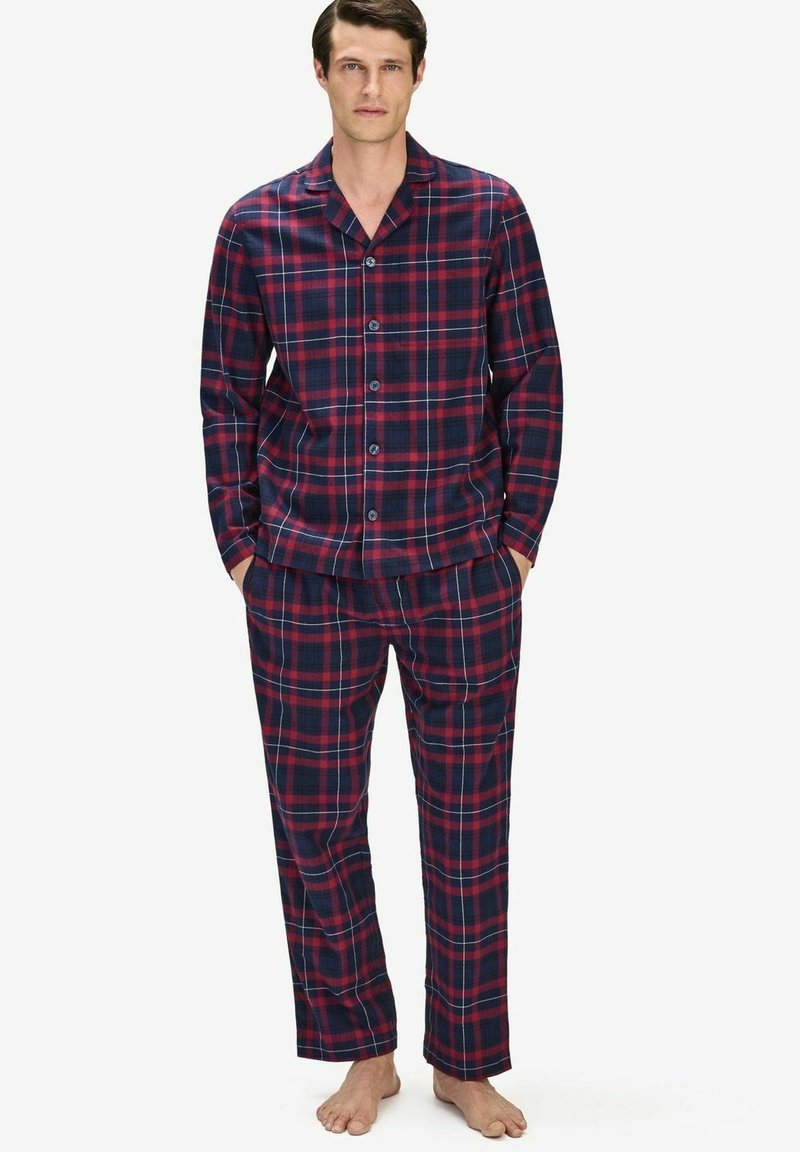 Rutig pyjamasset i marinblått och vinrött. Långärmad knäpptröja, matchande byxor. Mjuk tyg med avslappnad passform. Inga synliga mönster eller accenter.