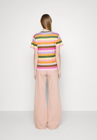 Meermaals gestreept T-shirt van zacht katoen, met horizontale lijnen in roze, groen, geel en paars. Losse pasvorm, korte mouwen.