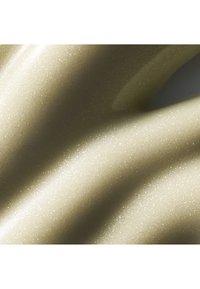 Krämig, iriserande lotion med en mjuk, slät textur i blek beige, med subtilt skimmer och flytande vågmönster.