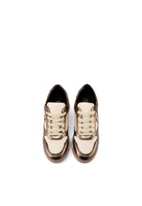 Sneakers con tomaia in pelle beige e accenti metallici bronzo, punta rotonda, lacci piatti e suola testurizzata.