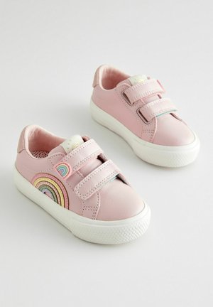 Rozā ādas sporta apavi ar Velcro siksnām, apaļa forma, balta gumijas zole un daudzkrāsains varavīksnes dizains sānos. Gluda tekstūra.