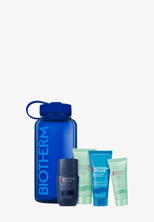 Blaue Plastik-Wasserflasche mit Schraubverschluss, vier Kosmetik-Tuben in Grün und Blau. Enthält Gel und Reiniger mit sichtbaren Etiketten und Marken.