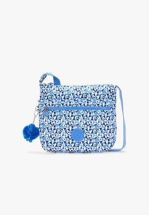 Blå mønstret crossover taske med hvide geometriske designs, der har en matchende rem, lynlåsrum og en blå pom-pom charme.
