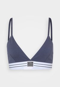 Marineblauwe bralette met een diepe V-hals, dunne bandjes en een witte gestreepte band met een logo. Glad materiaal met een minimalistisch ontwerp.