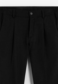 Pantalones negros con diseño de frente plisado, con cierre de botón y cintura elástica para mayor comodidad. Textura de tela suave.