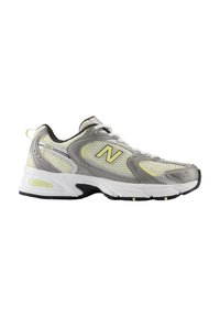 Zapatilla deportiva gris y blanca con parte superior de malla, acentuada con detalles en amarillo neón. Presenta una suela gruesa y puntera redondeada para mayor comodidad.