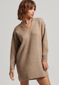 Vestido de suéter de cuello en V, de manga larga en marrón claro, fabricado con un tejido suave y texturizado, de corte relajado y con puños acanalados, que alcanza la mitad del muslo.