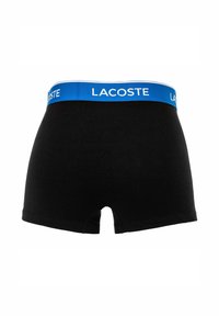 Boxer aderenti neri in cotone con elastico blu che presenta il logo bianco "LACOSTE". Tessuto morbido e vestibilità classica.