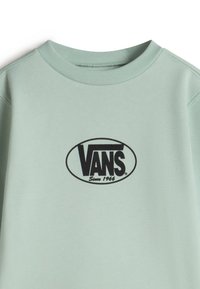 Hellgrüner Sweatshirt mit Rundhalsausschnitt. Besitzt ein schwarzes ovales Vans-Logo mit dem Text "Seit 1966". Glattes Baumwollmaterial.