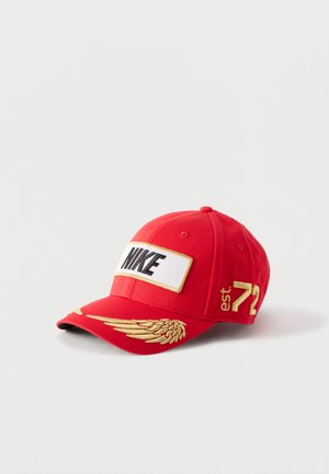 Șapcă de baseball roșie Nike cu logo negru pe o etichetă albă, aripă brodată auriu pe cozoroc și "est. 72" pe laterală.