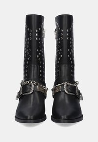 Botas negras de cuero hasta el tobillo con un diseño de tachuelas plateadas, cierre de cremallera y una correa decorativa con cadena y detalle de hebilla.