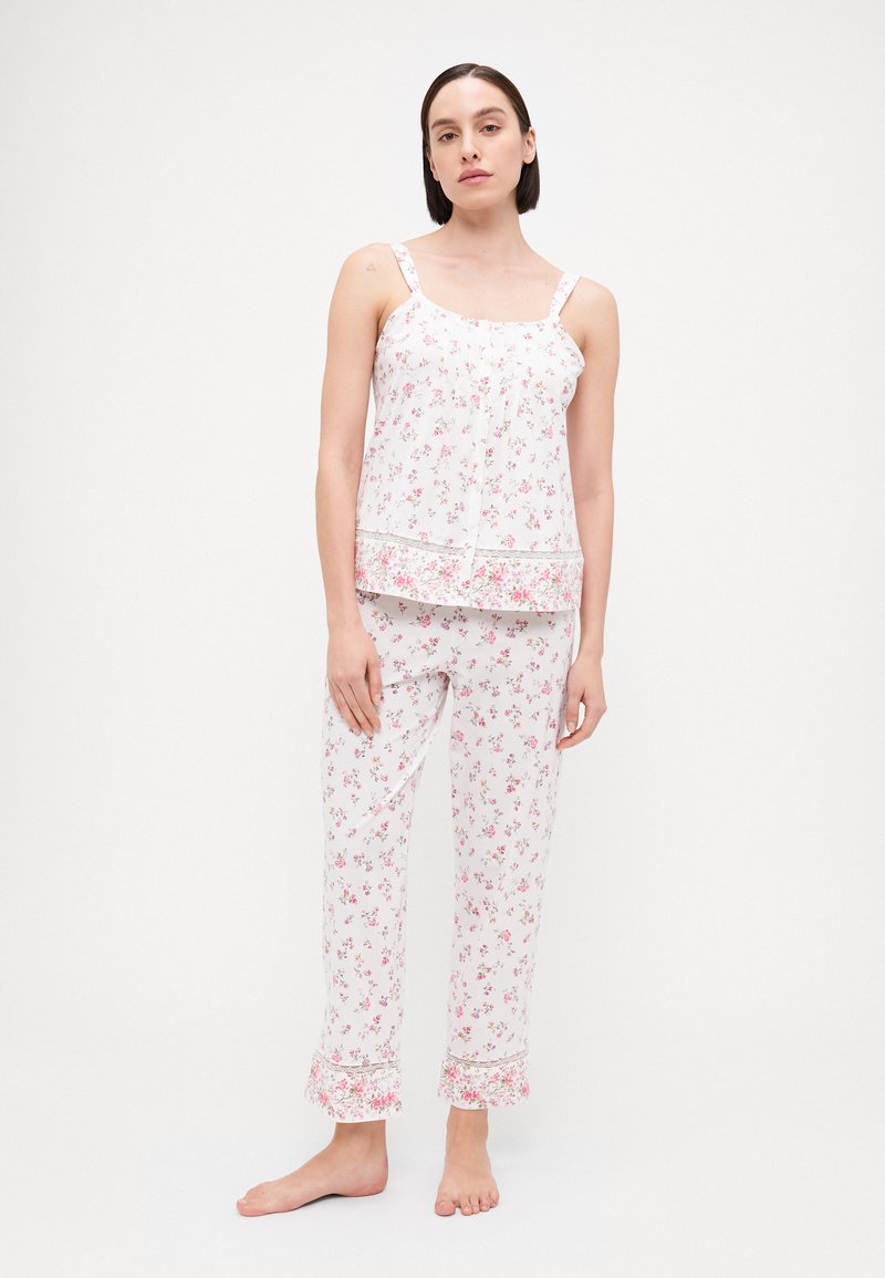 Ziedu raksta pidžamu komplekts gaiši rozā un baltā krāsā, ar bez piedurknēm topiņu ar mežģīņu apdari un atbilstošām biksēm ar rakstainām piedurknēm. Mīksta auduma.