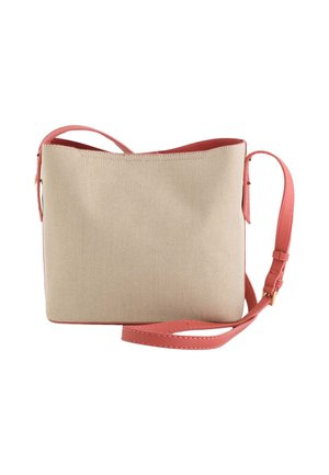 Sac bandoulière en tissu texturé beige avec des accents et une sangle en cuir rose, présentant une forme rectangulaire simple et une ouverture sur le dessus.