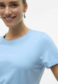 T-shirt di cotone azzurro chiaro con scollatura a girocollo e maniche corte, caratterizzato da una texture liscia e un design aderente.