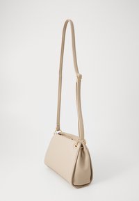 Beige syntetisk lædertaske med en trekantet form, justerbar rem, guldfarvede metaldele og en struktureret overflade.
