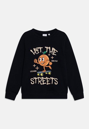 Sweatshirt noir en coton avec un personnage de dessin animé orange faisant du skateboard, accompagné du texte : « ENVERS LA RUE », « PLUS DE JEU » et « MOINS DE TRAVAIL ».