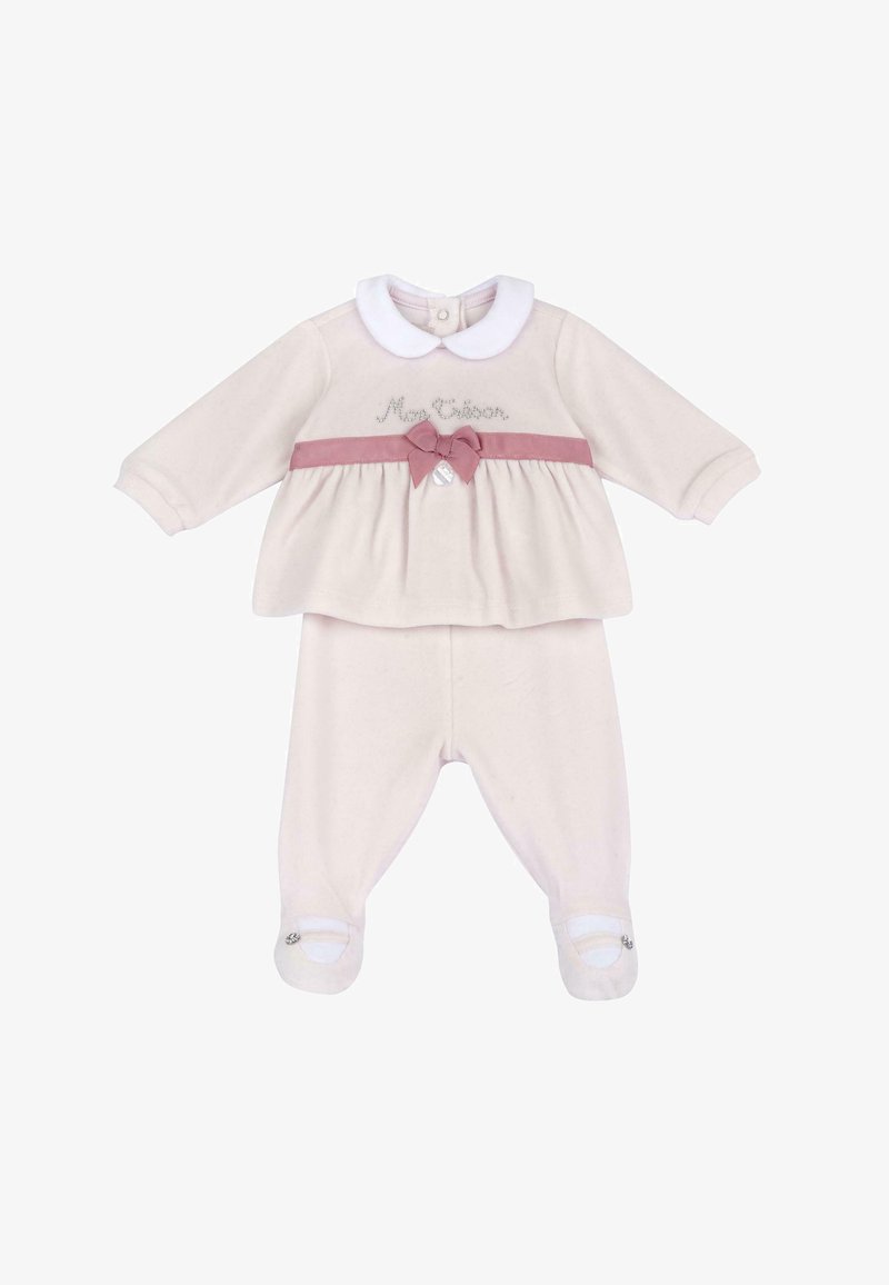 Krémový dětský outfit obsahující dlouhý rukáv top s bílým límcem, růžovými mašličkami a odpovídajícími kalhotami se špičkami.