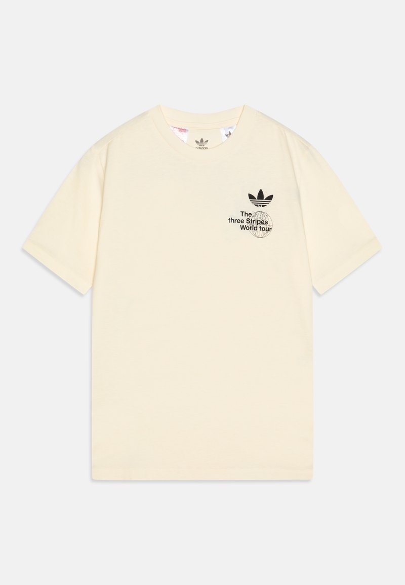 Camiseta de manga corta color crema de Adidas con el texto y el logo en negro "The three Stripes World Tour" impresos en el lado izquierdo del pecho.