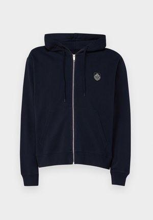 Tamsiai mėlynas zip-up džemperis, pagamintas iš minkštos medžiagos, turintis priekinę kišenę, su raišteliu reguliuojamą kapučiną ir išsiuvinėtą logotipą kairiajame krūtinės kampe.
