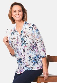 Bluse mit floralem Muster in Weiß, blau, lila und pink. Mit durchgehender Knopfleiste, Kragen und Dreiviertelärmeln.