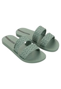 Infradito verdi in gomma con cinturini intrecciati e suole decorate. Due cinture larghe con una finitura testurizzata, caratterizzate da un accento di glitter sottile.