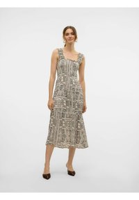 Mouwloze jurk tot de knie in beige met zwarte abstracte patronen. Beschikt over een vierkante halslijn en geraffineerde schouderbanden. Lichtgewicht stof.