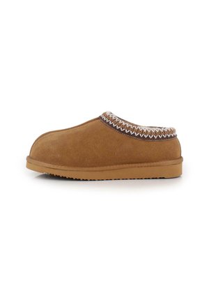 Zapatilla de ante marrón con un diseño redondeado, que presenta un borde texturizado y una suela de goma. Destaca por sus líneas simples y limpias.