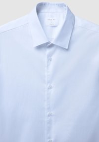 Camicetta slim-fit azzurra con colletto a punta, caratterizzata da una texture di tessuto liscia e sei bottoni lungo la parte anteriore.